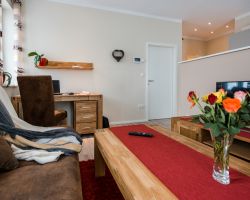 Wohnbereich mit Schreibtisch, Couch und TV