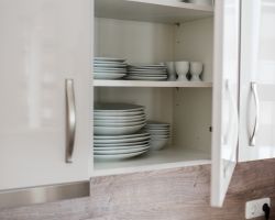 Geöffneter Küchenschrank mit Geschirr