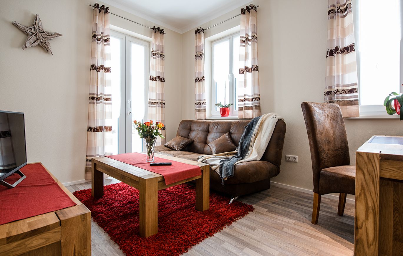 Wohnbereich mit Ledercouch im Business Apartment Franken